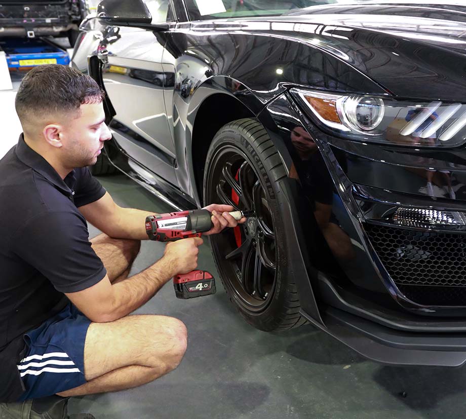 parramatta smash repair technician drilling car wheel on